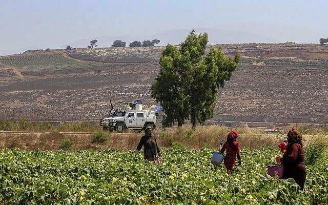 Photo d'illustration : Des agriculteurs travaillent dans la plaine de Marjayoun, à côté du village de Khiam, au sud du Liban, face à la ville israélienne de Metula, le long de la frontière avec Israël, le 26 aout 2019 (Crédit :  Mahmoud ZAYYAT / AFP)