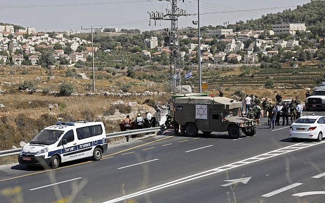 Les forces de sécurité et les médecins israéliens sur les lieux d'un attentat à la voiture piégée à proximité de Elazar, le 16 août 2019. (Ahmad GHARABLI / AFP)