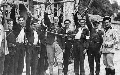 Des combattants de la Résistance française locale agitent leurs fusils en saluant les troupes britanniques dans le village de Quillebeuf, en France, en août 1944. (Photo AP)