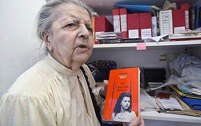 Madeleine Riffaud, poète, journaliste et membre de la Résistance française, répondant à un journaliste lors d'une interview accordée à l'Associated Press à Paris. Elle tient un livre qu'elle a écrit, avec en couverture, une photo d'elle durant la Seconde Guerre mondiale, le 19 août 2014. (Crédit : Michel Euler/AP)