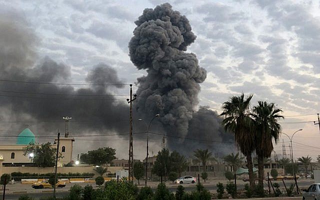 De la fumée s'élève après une explosion sur une base militaire au sud-ouest de Bagdad, en Irak, le 12 août 2019. (Crédit : AP Photo/Loay Hameed)