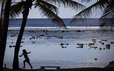 Un enfant joue sur un plage de Nauru, dans les îles du Pacifique, le 3 septembre 2018; (Crédit : Jason Oxenham/Pool Photo via AP)
