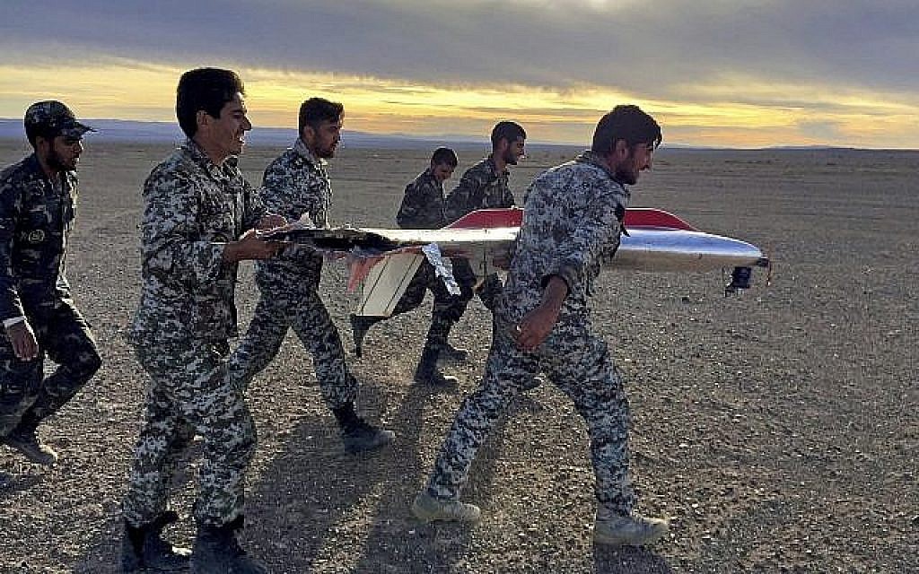 Sur cette photo fournie par l'armée iranienne, des soldats transportent les débris d'un drone durant des exercices à Semnan, en Iran (Crédit : Armée iranienne via AP)