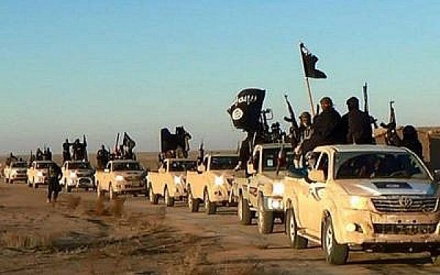 Photo d'lllustration : Sur cette photo d'archive non datée publiée par un site Web militant, qui a été vérifiée et qui correspond à d'autres rapports de l'AP, des djihadistes du groupe État islamique brandissent leurs armes et agitent ses drapeaux sur leurs véhicules dans un convoi vers l'Irak, à Raqqa, en Syrie. (Crédit : Site web militant/ AP) Photo d'lllustration : Sur cette photo d'archive non datée publiée par un site Web militant, qui a été vérifiée et qui correspond à d'autres rapports de l'AP, des djihadistes du groupe État islamique brandissent leurs armes et agitent ses drapeaux sur leurs véhicules dans un convoi vers l'Irak, à Raqqa, en Syrie. (Crédit : Site web militant/ AP)