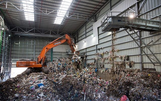 Un bulldozer soulève des déchets à l'usine de recyclage de Greenet, dans la zone industrielle d'Atarot, au nord de Jérusalem, le 16 juin 2015 (Crédit : Yonatan Sindel/Flash90)