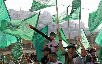 Des Palestiniens agitant des drapeaux du Hamas  et scandent des slogans lors d'une fête organisée par le Hamas dans la ville cisjordanienne de Naplouse, le vendredi 29 août 2014. (AP/Nasser Ishtayeh)