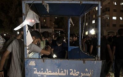Des Palestiniens observent un poste de contrôle de la police après qu'une exposition a ciblé un barrage de la police à Gaza Ville, le mardi 27 août 2019. (AP Photo/Khalil Hamra)