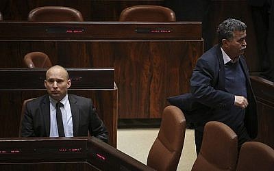 Amir Peretz (droite) passe à côté de Naftali Bennett lors d'une sessions plénière de la Knesset le 21 janvier 2015. (Hadas Parush/Flash90)
