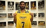Omri Casspi tenant un maillot du Maccabi de Tel aviv après avoir annoncé son retour au club après une décennie en NBA, el 13 août 2019. (Crédit : Site officiel du Maccabi Tel Aviv)