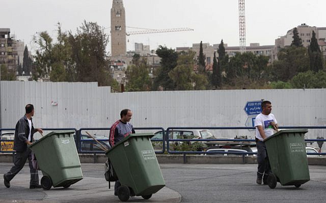Trois hommes poussent des poubelles vertes à Jérusalem, le 27 octobre 2009 (Crédit : Nati Shohat/FLASH90)