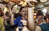 Ayelet Shaked prend un verre avec des jeunes pendant sa campagne électorale, le 31 août 2019. (Crédit : MENAHEM KAHANA / AFP)