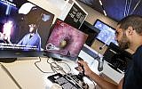 Un visiteur utilise un joystick pour examiner un coeur virtuel, lors d'une expositions de RealView, au Centre Peres pour la paix et l'innovation de Tel-Aviv, le 3 septembre 2019. (Crédit : JACK GUEZ / AFP)