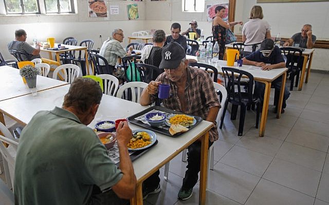 Des personnes défavorisées déjeunent à Lasova, une soupe populaire à Tel Aviv, le 8 septembre 2019. (Crédit : MENAHEM KAHANA / AFP)