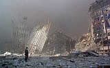 Sur cette photo d'archives prise le 11 septembre 2001, un homme se tient debout dans les décombres et demande si quelqu'un a besoin d'aide, après l'effondrement de la première tour du World Trade Center à New York City. (Crédit :  DOUG KANTER / AFP)