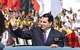 Sur cette photo d'archives prise le 20 mars 2006, l'ancien président tunisien Zine El Abidine Ben Ali salue la foule à son arrivée au stade de Radès, où il prononce son discours à l'occasion du cinquantième anniversaire de l'indépendance de la Tunisie par la France. (Crédit : Handout / AFP)