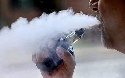 Un homme expulse de la fumée après avoir actionné sa cigarette électronique à Portland, dans le Maine, le 28 août 2019. (Crédit : AP/Robert F. Bukaty, File)