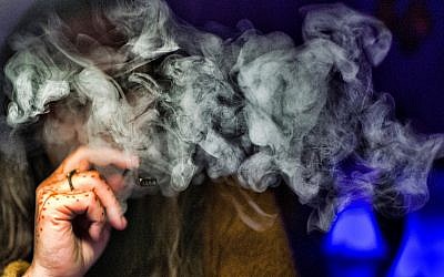 Une femme fume du cannabis avec une cigarette électronique, à Los Angeles, le 22 novembre 2018, (Crédit : AP/Richard Vogel)