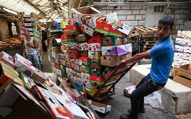 Des employés recyclent les cartons de fruits et de légumes au marché Mahane Yehuda de Jérusalem, le 25 juin 2015 (Crédit :  Nati Shohat/FLASH90)