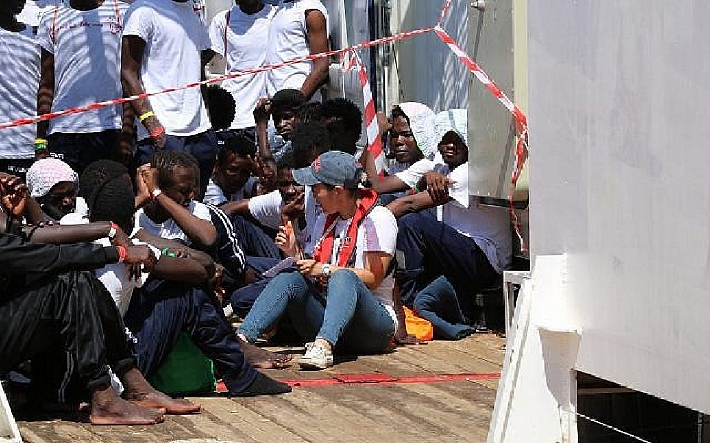 Une secouriste avec des réfugiés à bord de l'Ocean Viking, au mois d'août 2019 (Crédit : Hannah Wallace Bowman/SOS Méditerranée)