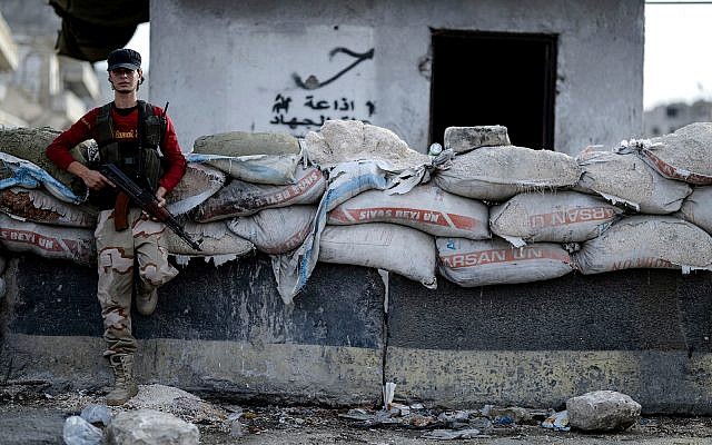Un combattant de l'opposition syrienne à un point de passage dans la ville d'Idleb, le 13 octobre 2018. (Crédit : Ugur Can/DHA via AP)