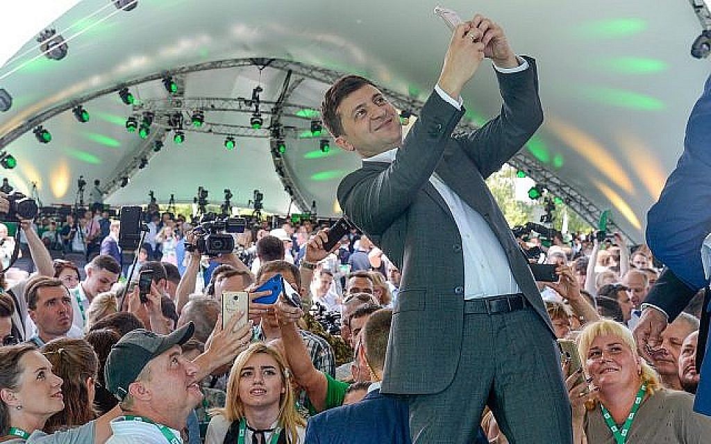 Le président ukrainien Volodymyr Zelensky prend un selfie au premier congrès de son parti, appelé Serviteur du peuple, dans le Jardin botanique municipal, Kiev, Ukraine, le 9 Juin 2019. (AP Photo/Zoya Shu) Le président ukrainien Volodymyr Zelensky prend un selfie au premier congrès de son parti, appelé Serviteur du peuple, dans le Jardin botanique municipal, Kiev, Ukraine, le 9 Juin 2019. (AP Photo/Zoya Shu)
