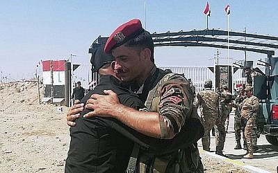 Des gardes frontière syriens et irakiens se congratulent lors de la cérémonie d'ouverture de la frontière entre la ville irakienne de Qaim et la ville syrienne de Boukamal dans la province d'Anbar, en Irak, le 30 septembre 2019. (AP Photo/Hadi Mizban)
