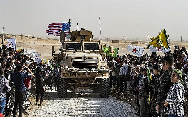 Les Kurdes syriens se réunissent autour d'un blindé américain durant une manifestation contre les menaces de la Turquie près d'une base de la coalition internationale dirigée par les Etats-Unis aux abords de Ras al-Ain, dans la province de Hasakeh, en Syrie, près de la frontière turque, le 6 octobre 2019. (Crédit : Delil Souleiman/AFP) Les Kurdes syriens se réunissent autour d'un blindé américain durant une manifestation contre les menaces de la Turquie près d'une base de la coalition internationale dirigée par les Etats-Unis aux abords de Ras al-Ain, dans la province de Hasakeh, en Syrie, près de la frontière turque, le 6 octobre 2019. (Crédit : Delil Souleiman/AFP)