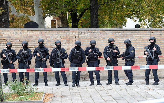 Des policiers se tiennent devant le mur d'un cimetière juif proche du site d'une fusillade à Halle an der Saale, à l'est de l'Allemagne, le 9 octobre 2019. (Crédit : Sebastian Willnow / dpa / AFP / Germany OUT) Des policiers se tiennent devant le mur d'un cimetière juif proche du site d'une fusillade à Halle an der Saale, à l'est de l'Allemagne, le 9 octobre 2019. (Crédit : Sebastian Willnow / dpa / AFP / Germany OUT)