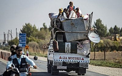 Des civils syriens arabes et kurdes arrivent dans la ville de Tall Tamr, dans la province de Hasakeh dans le nord-ouest de la Syrie, après avoir fui les bombardements turcs sur la région proche de la frontière turque, le 10 octobre 2019. (Crédit : Delil Souleiman/AFP)