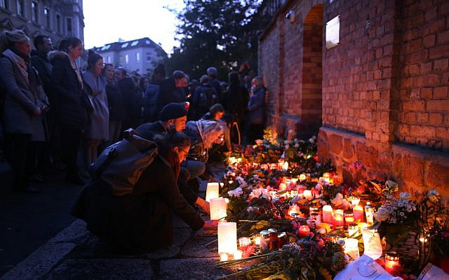 Des bougies allumées devant la synagogue de Halle, à l'est de l'Allemagne, 24 heures après une fusillade antisémite, le 10 octobre 2019. (Crédit : Ronny Hartmann / AFP)