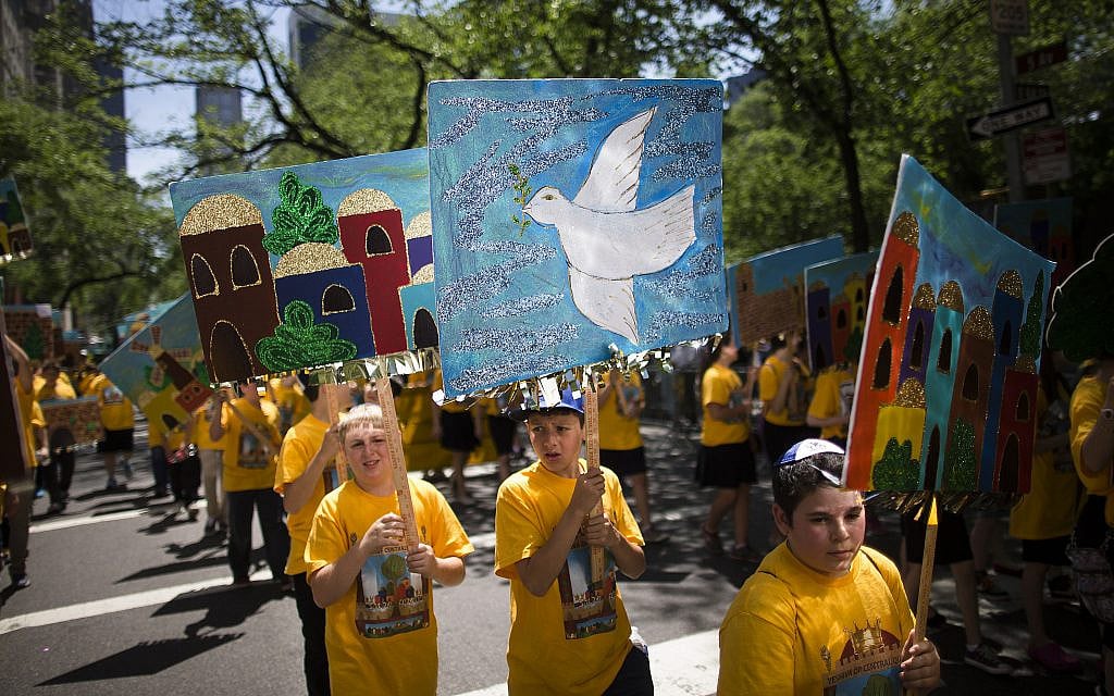 Un jeune garçon porte un panneau représentant une colombe de la paix avec d'autres élèves d'une école juive pendant le défilé Celebrate Israel à New York, le dimanche 1er juin 2014. (AP Photo/John Minchillo) Un jeune garçon porte un panneau représentant une colombe de la paix avec d'autres élèves d'une école juive pendant le défilé Celebrate Israel à New York, le dimanche 1er juin 2014. (AP Photo/John Minchillo)