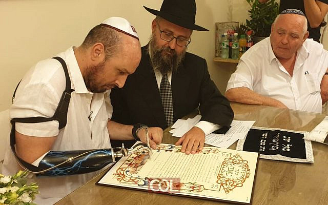 Ben Spitzer, le soldat le plus gravement blessé de l'opération Plomb durci contre Gaza, signe sa ketouba avant son mariage à Ashkelon, le 7 octobre 2019. (Crédit : Chabad Youth Organization) Ben Spitzer, le soldat le plus gravement blessé de l'opération Plomb durci contre Gaza, signe sa ketouba avant son mariage à Ashkelon, le 7 octobre 2019. (Crédit : Chabad Youth Organization)