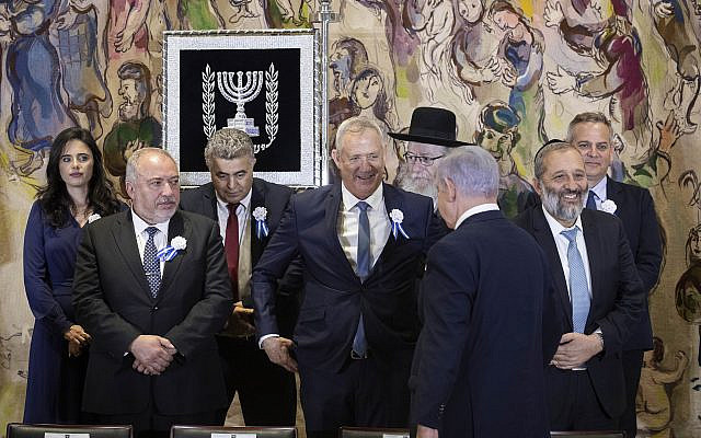 Le Premier ministre Benjamin Netanyahu (de dos) se dirige vers son rival Benny Gantz (au centre) alors qu'ils se préparent à poser pour une photo de groupe lors de la prestation de serment de la 22e Knesset à Jérusalem, le 3 octobre 2019, avec d'autres chefs de parti dont Avigdor Liberman (à gauche) et Aryeh Deri (à droite). (Hadas Parush/Flash90) Le Premier ministre Benjamin Netanyahu (de dos) se dirige vers son rival Benny Gantz (au centre) alors qu'ils se préparent à poser pour une photo de groupe lors de la prestation de serment de la 22e Knesset à Jérusalem, le 3 octobre 2019, avec d'autres chefs de parti dont Avigdor Liberman (à gauche) et Aryeh Deri (à droite). (Hadas Parush/Flash90)