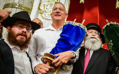 Benny Gantz, président du parti Kakhol lavan, porte un rouleau de la Torah alors qu'il danse pendant les célébrations de Simha Torah à Kfar-Habad, le 21 octobre 2019. (Yossi Zeliger/Flash90)