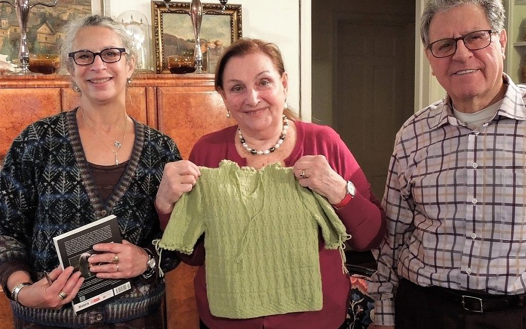 La docteure  Kristine Keren, au centre, avec une réplique de son pull vert de la Shoah fabriquée par la docteure Lea Stern, à gauche). L'époux de Keren, Marion, est à droite (Crédit : Julia Grossman)