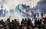Des manifestants s'en prennent à véhicules anti-émeute de la police irakienne au cours d'une manifestation contre la corruption de l'Etat et les mauvais services publics, entre la place Tahrir et le quartier de haute sécurité de la Ligne Verte de la capitale Baghdad, le 1 octobre 2019. (AHMAD AL-RUBAYE / AFP)