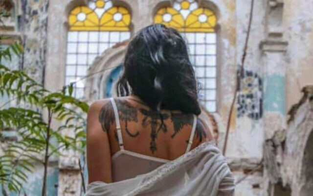Un modèle pose dans une synagogue roumaine dilapidée. (Edy Rosen/Facebook via JTA)