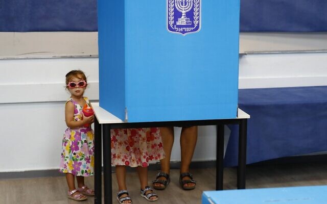 Des enfants israéliens accompagnent leur père lors des élections parlementaires dans un bureau de vote de Rosh Haayin, le 17 septembre 2019 (Crédit : Jack GUEZ / AFP)