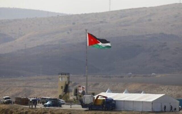 Photo prise du côté israélien de la frontière : des soldats jordaniens plantent le drapeau national avant une cérémonie dans la vallée du Jourdain, à Naharayim, le 10 novembre 2019. (Crédit : MENAHEM KAHANA / AFP)
