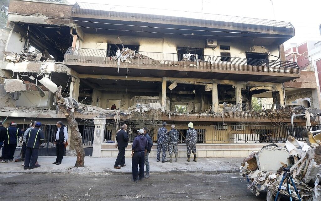 Les forces de sécurité et des employés de la mairie devant une immeuble visé par une frappe en Syrie, le 12 novembre 2019. (Crédit : LOUAI BESHARA / AFP)