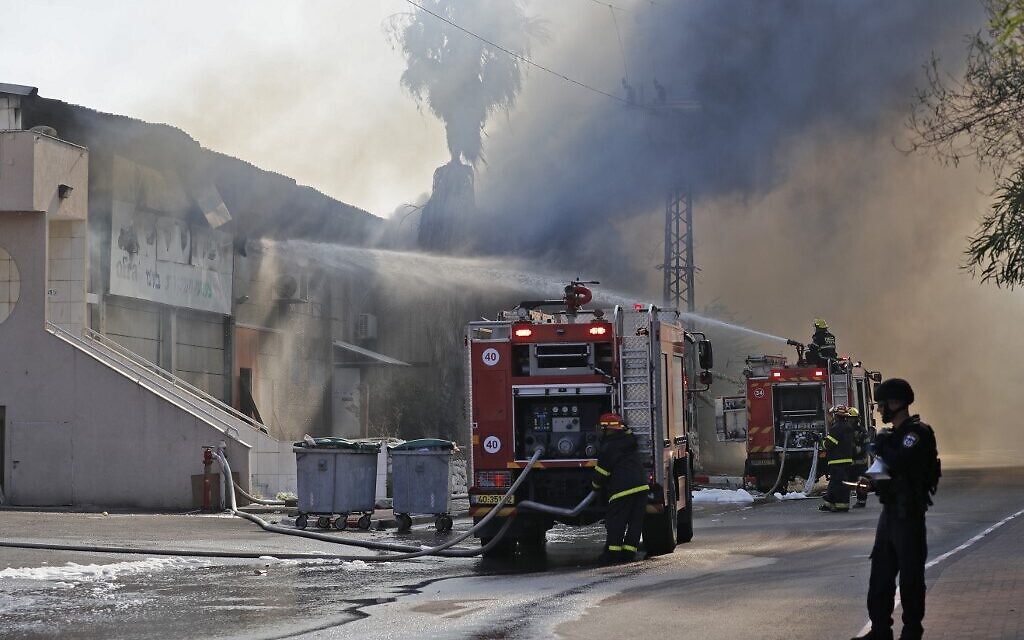Des pompiers israéliens tentent de maîtriser un incendie qui ravage un entrepôt à Sderot, après qu'une roquette tirée depuis Gaza a frappé le bâtiment, le 12 novembre 2019. (Crédit : Ahmad GHARABLI / AFP)