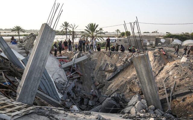 Des Palestiniens réunis autour des restes d'une maison détruite dans une frappe aérienne israélienne à Khan Younès, dans le sud de la bande de Gaza, le 13 novembre 2019 (Crédit : SAID KHATIB / AFP) Des Palestiniens réunis autour des restes d'une maison détruite dans une frappe aérienne israélienne à Khan Younès, dans le sud de la bande de Gaza, le 13 novembre 2019 (Crédit : SAID KHATIB / AFP)