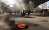 Des manifestants iraniens incendient des pneus pendant une manifestation contre la hausse des prix du carburant, à Ispahan, le 16 novembre 2019. (Crédit : AFP)