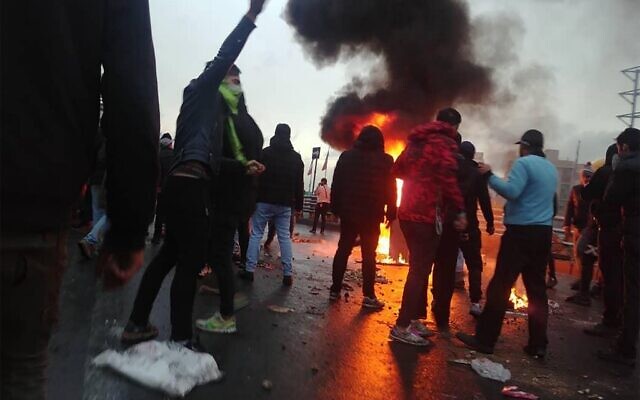 Des manifestants iraniens se rassemblent autour d'un feu lors d'une manifestation contre la hausse des prix de l'essence dans la capitale Téhéran, le 16 novembre 2019. (Crédit : AFP) Des manifestants iraniens se rassemblent autour d'un feu lors d'une manifestation contre la hausse des prix de l'essence dans la capitale Téhéran, le 16 novembre 2019. (Crédit : AFP)