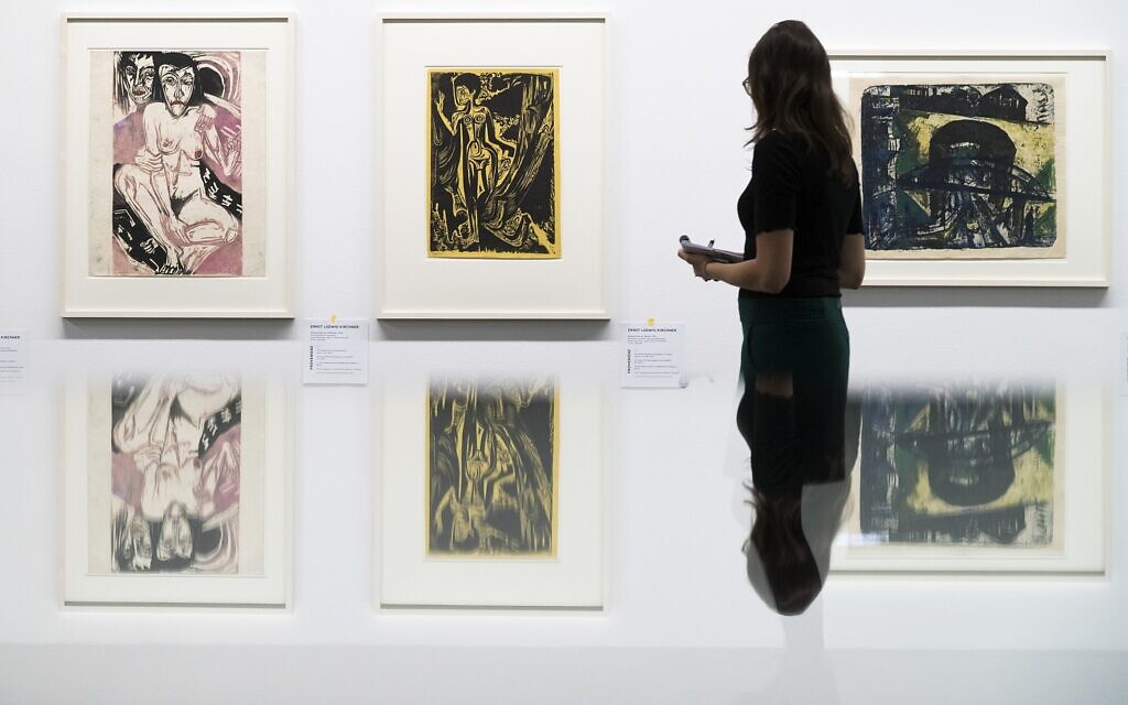 Une visiteuse regarde les peintures "Melancholisches Maedchen", à gauche, et Nackte Frau im Walde" du peintre allemand  Ernst Ludwig Kirchner, dans l'exposition ‘Rapport de statut Gurlitt. Art dégénéré - confisqué et vendu' organisée au Kunstmuseum de Bern, en Suisse, le 1er novembre 2017 (Crédit : Peter Klaunzer/Keystone via AP)