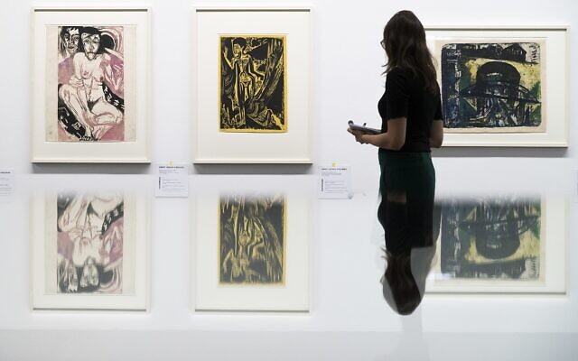 Une visiteuse regarde les peintures "Melancholisches Maedchen", à gauche, et Nackte Frau im Walde" du peintre allemand  Ernst Ludwig Kirchner, dans l'exposition ‘Rapport de statut Gurlitt. Art dégénéré - confisqué et vendu' organisée au Kunstmuseum de Bern, en Suisse, le 1er novembre 2017 (Crédit : Peter Klaunzer/Keystone via AP)