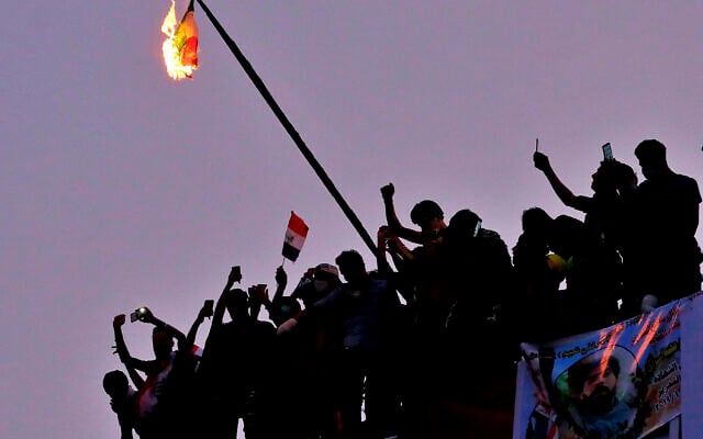 Des manifestants anti-gouvernementaux irakiens brûlent le drapeau iranien lors d'une manifestation à Bagdad, en Irak, le mardi 29 octobre 2019. (Crédit : AP / Hadi Mizban)