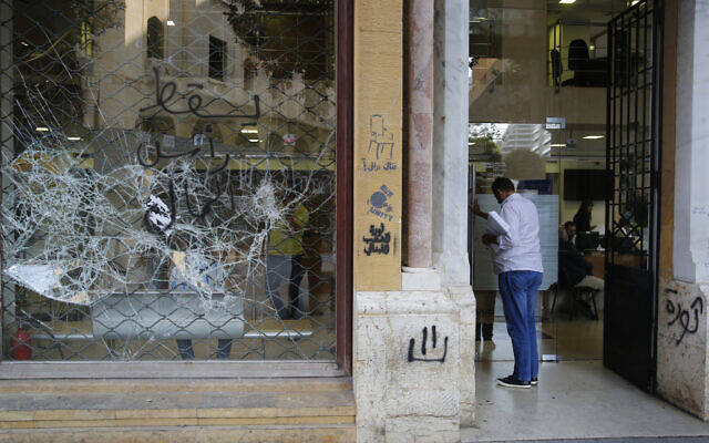 Un client entre dans une banque à la vitrine brisée après des manifestations anti-gouvernement, à Beyrouth, au Liban, le 1er novembre 2019. (Crédit : AP Photo/Hussein Malla) Un client entre dans une banque à la vitrine brisée après des manifestations anti-gouvernement, à Beyrouth, au Liban, le 1er novembre 2019. (Crédit : AP Photo/Hussein Malla)