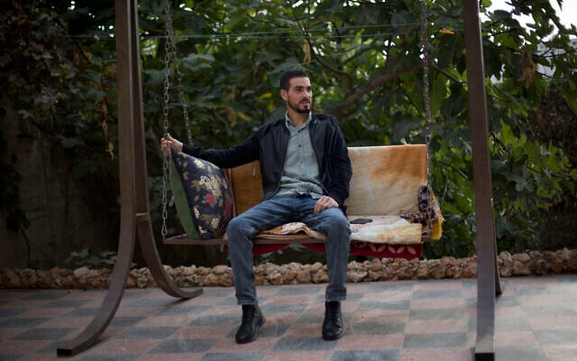 Le Palestinien Karam Qawasmi, qui a été blessé dans le dos par balle par les forces israéliennes lors d'un incident filmé l'an dernier, est assis dans son jardin, à Hébron, en Cisjordanie, le dimanche 10 novembre 2019. (AP Photo/Majdi Mohammed)
