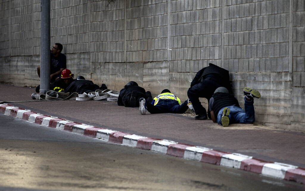 Des Israéliens se protègent au sol durant une sirène d'alarme à la roquette, à Sdérot le 12 novembre 2019. (Crédit : AP Photo/Tsafrir Abayov)